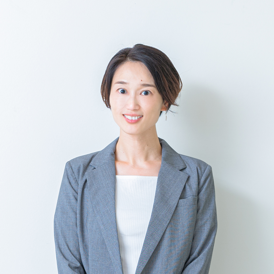 株式会社タラントンの代表前田聖子のプロフィール写真です。グレイのジャケットを着たバストアップ、笑顔の写真です。